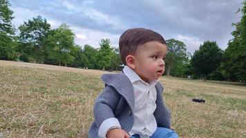 schattige kleine baby baby poseert in een plaatselijk openbaar park in de stad Luton in Engeland video