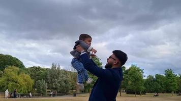 Aziatische Pakistaanse vader houdt zijn 11 maanden oude baby vast in het plaatselijke park video