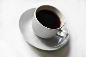 Tea pair with poured tea on a white background. Porcelain cup and saucer with tea. photo