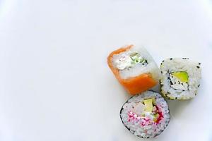 rollos de arroz con carne sobre un fondo blanco. delicioso sushi foto