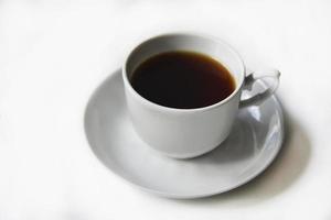 Tea pair with poured tea on a white background. Porcelain cup and saucer with tea. photo