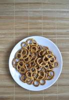 Salty delicious pretzel on a white tea plate. photo