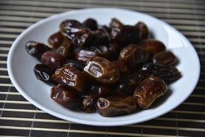 Juicy delicious dates on a white plate. photo