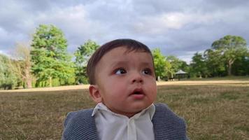 Süßes kleines Baby posiert in einem örtlichen öffentlichen Park der Stadt Luton in England, Großbritannien video