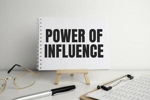 power of influence, text on white paper on the light background with charts paper photo