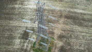 hoogspanningsvoedingspalen met kabels die door de britse landbouwgronden en het platteland lopen, vanuit de lucht bekeken vanuit een hoge hoek door de camera van de drone video