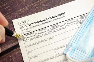 health insurance form with pen on wooden background photo