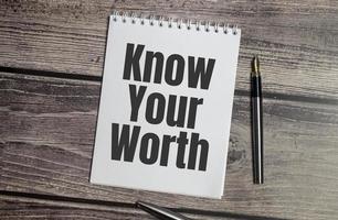 Know Your Worth words on notepad and wooden background photo