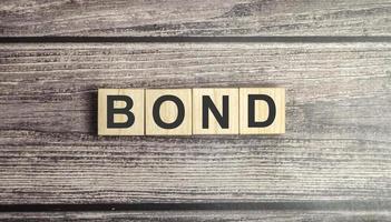 palabra de enlace en bloque de madera. un bono es un valor que indica que el inversor ha otorgado un préstamo al emisor foto