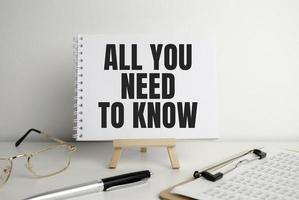 All you need to know, text on white paper on the light background with charts paper photo