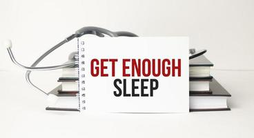 Get enough sleep symbol on notepad and stethoscope photo