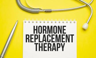 HRT Hormone Replacement Therapy written in notebook on yellow table photo
