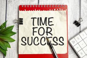 time for success words on notepad and pen on wooden background photo