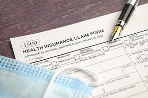 health insurance form with pen on wooden background photo