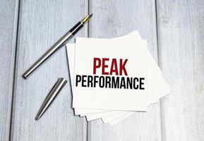 Text PEAK PERFORMANCE . Beautiful wooden background. Business concept, copy space. photo