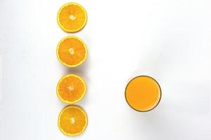 arreglo de piezas de naranjas jugosas con un vaso de naranja aislado sobre fondo blanco, estilo de concepto de vista superior foto