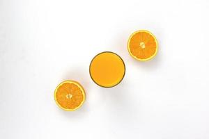 Two pieces of juicy oranges with glass of orange isolated on white background, placed in the center of BG, Top view concepts photo