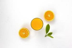 Two pieces of juicy oranges with glass of orange and green leaf isolated on white background, placed in the center of Top view concepts Background photo