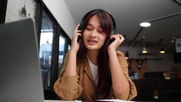 Close up shot, pretty teenage sitting and enjoy to listening musice from wireless headphone and singing together, lifestyle concept video