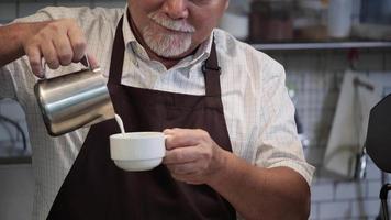 Senior man barista makes coffee after counter table. video