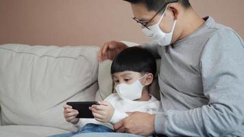 padre e figlio con smartphone e maschera video