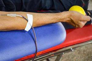 Blood donor at Blood donation camp held with a bouncy ball holding in hand at Balaji Temple, Vivek Vihar, Delhi, India, Image for World blood donor day on June 14 every year, Blood Donation Camp photo