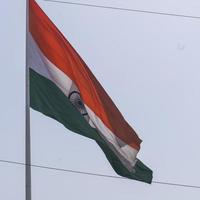 India flag flying high at Connaught Place with pride in blue sky, India flag fluttering, Indian Flag on Independence Day and Republic Day of India, tilt up shot, waving Indian flag, Flying India flags photo