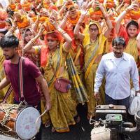 New Delhi, India April 03 2022 - Women with Kalash on head during Jagannath Temple Mangal Kalash Yatra, Indian Hindu devotees carry earthen pots containing sacred water with a coconut on top photo