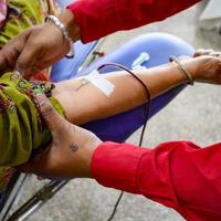 Blood donor at Blood donation camp held with a bouncy ball holding in hand at Balaji Temple, Vivek Vihar, Delhi, India, Image for World blood donor day on June 14 every year, Blood Donation Camp photo