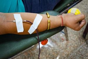 donante de sangre en el campamento de donación de sangre sostenido con una pelota hinchable en la mano en el templo balaji, vivek vihar, delhi, india, imagen para el día mundial del donante de sangre el 14 de junio de cada año, campamento de donación de sangre foto