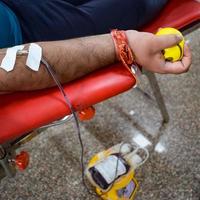 Blood donor at Blood donation camp held with a bouncy ball holding in hand at Balaji Temple, Vivek Vihar, Delhi, India, Image for World blood donor day on June 14 every year, Blood Donation Camp photo