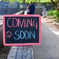 Indian couple posing for maternity baby shoot. The couple is posing in a lawn with green grass and the woman is falunting her baby bump in Lodhi Garden in New Delhi, India photo