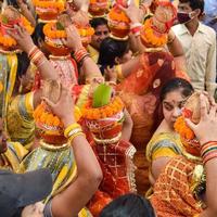 New Delhi, India April 03 2022 - Women with Kalash on head during Jagannath Temple Mangal Kalash Yatra, Indian Hindu devotees carry earthen pots containing sacred water with a coconut on top photo