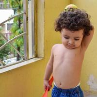 lindo niño shivaay en el balcón de la casa durante el verano, dulce sesión de fotos de niño pequeño durante el día, niño pequeño disfrutando en casa durante la sesión de fotos