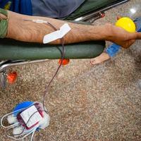 donante de sangre en el campamento de donación de sangre sostenido con una pelota hinchable en la mano en el templo balaji, vivek vihar, delhi, india, imagen para el día mundial del donante de sangre el 14 de junio de cada año, campamento de donación de sangre foto