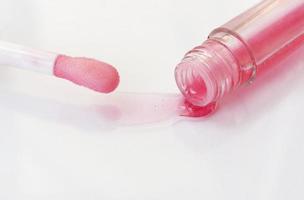 The texture of the lip balm. Oil, transparent liquid flows out of the tube. Image on a white background. photo