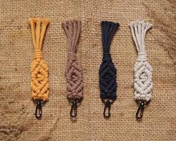 llavero de macrame, chupito de macrame, hecho a mano por mujeres en casa. excelentes imágenes de bricolaje para pancartas y anuncios de macramé y artesanías. diseño de pasatiempo creativo con accesorios, vista superior. macramé hecho a mano. foto