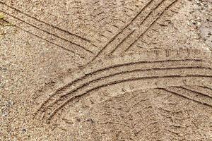 car tire tracks on a sandy road photo