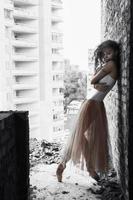 a charming ballerina in a bodysuit poses ballet elements in a headdress in a photo studio