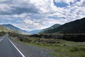 ribbon of the road among the slopes of the mountains on the expanses of Altai on a summer day photo