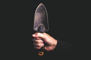 trowel for gardening  in a man hand - maintenance service concept photo