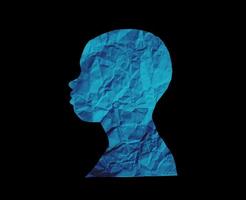 Human head silhouette with black background. People portrait with crumpled paper texture. Paper cut people from side angle. photo