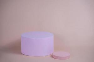 podio vacío para mostrar productos cosméticos. arreglo de plataforma en color rosa pastel en estilo minimalista moderno. composición de diseño de cilindros y cubos para fondo femenino
