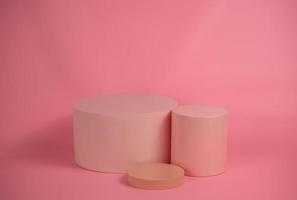 Empty podium for display cosmetic product. Platform arrangement in pink pastel color in trendy minimalist style. Composition of cylinders and cubes layout for feminine background photo