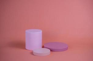 Empty podium for display cosmetic product. Platform arrangement in pink pastel color in trendy minimalist style. Composition of cylinders and cubes layout for feminine background photo