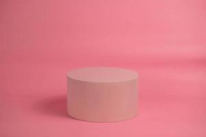 Empty podium for display cosmetic product. Platform arrangement in pink pastel color in trendy minimalist style. Composition of cylinders and cubes layout for feminine background photo