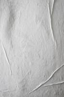 papel pegado blanco en blanco para superposición de textura de póster. patrón arrugado y arrugado para el fondo. papel mojado mate para carteles de maquetas, volantes, folletos y diseño de pancartas foto