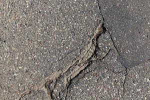 una carretera asfaltada con muchos agujeros y baches foto