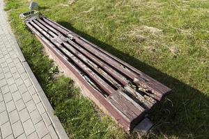 an old rotting wooden bench in the park photo