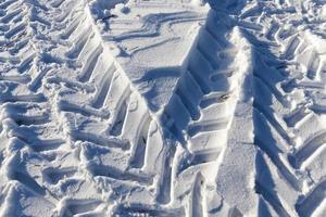 rastros del coche en la nieve foto